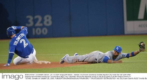 Kansas City Royals shortstop Alcides Escobar (R) holds the ball aloft after tagging second base forcing out Toronto Blue Jays Troy Tulowitzki during the seventh inning in the ALCS game 4 at the Rogers Centre in Toronto, Canada on October 20, 2015.  TOR2015102037 KEVINxDIETSCH