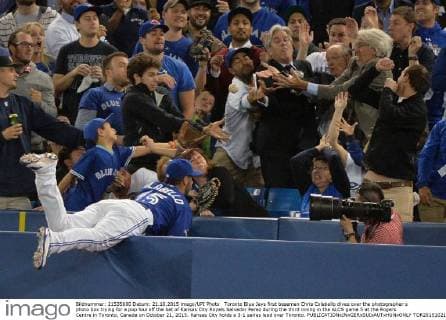 Toronto Blue Jays first baseman Chris Colabello dives over the photographer s photo box trying for a pop foul off the bat of Kansas City Royals Salvador Perez during the third inning in the ALCS game 5 at the Rogers Centre in Toronto, Canada on October 21, 2015. Kansas City holds a 3-1 series lead over Toronto.  TOR2015102113 KEVINxDIETSCH