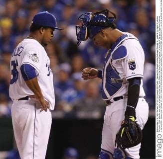 Kansas City Royals pitcher Edinson Volquez (L) looks at the hand of catcher Salvador Perez after he was hit by a foul ball by the New York Mets in the fourth inning of game 1 of the World Series at Kauffman Stadium in Kansas City, Missouri on October 27, 2015.  KCP20151027219 JEFFxMOFFETT