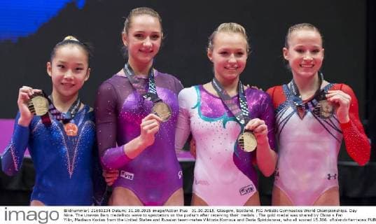 31.10.2015. Glasgow, Scotland. FIG Artistic Gymnastics World Championships. Day Nine. The Uneven Bars medallists wave to spectators on the podium after receiving their medals . The gold medal was shared by China s Fan Yilin, Madison Kocian from the United States and Russian team-mates Viktoria Komova and Daria Spiridonova, who all scored 15.366. xRolandxHarrisonx  ActionPlus11677856