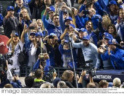 The Kansas City Royals fans celebrate as Kansas City Royals catcher Salvador Perez (hidden) holds up the trophy after they beat the New York Mets 7-2 to win the World Series in game 5 at Citi Field in New York City on November 1, 2015.  NYP20151101335 RAYxSTUBBLEBINE
