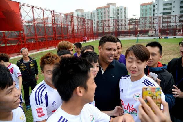 Brazilian football star Ronaldo Luiz Nazario de Lima, center, poses with young students for a selfie during a football event in Macau, China, 11 November 2015. Ronaldo shows up to highlight football event in Macau  20151111_63446
