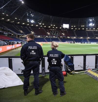 FUSSBALL INTERNATIONAL TESTSPIEL IN HANNOVER Deutschland - Holland 18.11.2015 Das Spiel wurde aus Sicherheitsbedenken kurzfristig abgesagt und evakuiert. Zwei Polizisten beobachten um 1 Uhr am Donnerstag die HDI-Arena in Hannover, waehrend Sportfotografen ihr Fotoequipment aus dem Innenraum des Stadions holen 