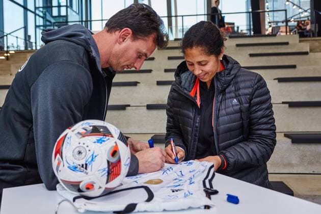 GER, Besuch der Frauen-Nationalmannschaft im Deutschen Fussball Museum 27.11.2015, Deutsches Fussball Museum, Dortmund, im Bild Michael Fuchs (Torwarttrainer) und Steffi Jones (Assistenztrainerin) unterzeichnen Trkiots und Baelle der Nationalmannschaft Sarah RauchnphxRauch