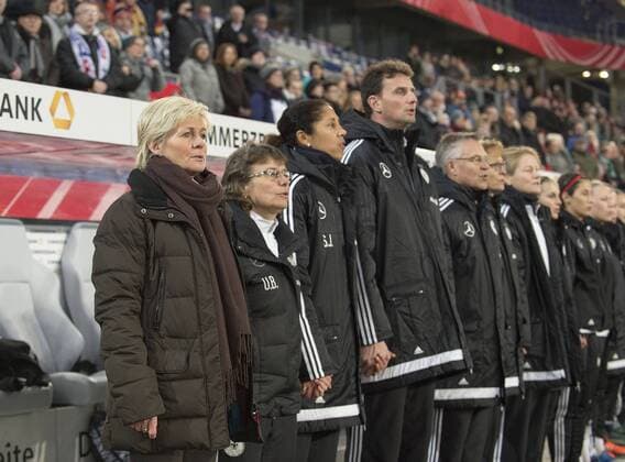v.l. Bundestrainerin Trainerin Trainer Silvia NEID, Co-Trainerin Ulrike BALLWEG, Co-Trainerin Steffi JONES, Torwarttrainer Michael FUCHS (GER) Hand in Hand waehrend der Nationalhymne, Fussball Frauen Freundschaftsspiel, Deutschland (GER) - England (ENG) 0:0, am 26.11.2015 in Duisburg Deutschland.