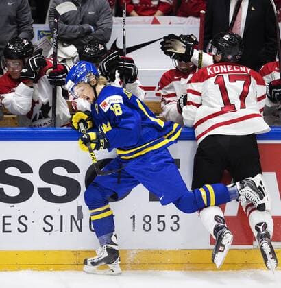 151231 Sveriges Rasmus Asplund blir tacklad av Kanadas Travis Konecny under ishockeymatchen i junior-VM mellan Kanada och Sverige den 31 december 2015 i Helsingfors.  Copyright: JOELxMARKLUND BB151231JM076
