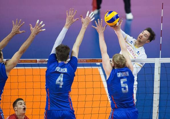 Berlin, Deutschland, 06.01.2016: Volleyball Olympia Qualifikation Männer Maenner 2016 - Spiel 6 Russland - Frankreich. Kevin Tillie (France 7) gegen den Block aus Artem Volvich (Russia 4) und Sergey Grankin (Russia 5)