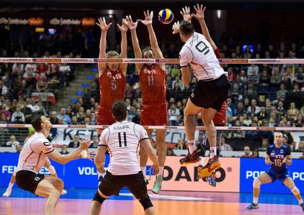 Georg GROZER (9 GER) im Angriff gegen Sergey GRANKIN (5 RUS), Andrey ASHCHEV (11 RUS) und Egor KLIUKA (19 RUS) Halbfinale: Russland - Deutschland am 09.01.2016 Volleyball Europaeisches Olympia Qualifikationsturnier 2016 in Berlin, Deutschland,