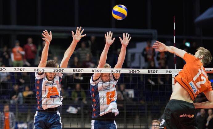 Berlin, Deutschland, 13.01.2016: Volleyball Bundesliga Saison 2015 2016 - Berlin Recycling Volleys - SVG Lueneburg Lüneburg. Paul Carroll (BR Volleys 12) gegen den Block aus Michel Schlien (Lüneburg 14) und Nicolas Marks (Lüneburg 11)