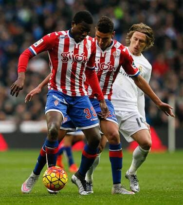 Real Madrid s Croatian midfielder Luka Modic (C) fights for the ball with Sporting Gijon s Cameroonian Daniel Ndi (L) during the Spanish Primera Division soccer match at Santiago Bernabeu stadium in Madrid, Spain, 17 January 2016. REAL MADRID VS SPORTING GIJON !ACHTUNG: NUR REDAKTIONELLE NUTZUNG!  MD 20160117-635886492138022490