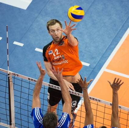 Berlin, Deutschland, 07.02.2016: Volleyball Bundesliga Saison 2015 2016 - Berlin Recycling Volleys - VfB Friedrichshafen. Paul Carroll (BR Volleys 12) gegen den Block aus Björn Bjoern Andrae (VfB Friedrichshafen 8) und Marc-Anthony Honore (VfB Friedrichshafen 9)