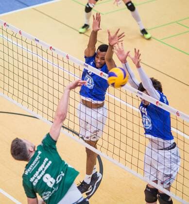 Berlin, Deutschland, 09.02.2016: Volleyball Bundesliga Saison 2015 2016 - Netzhoppers KW-Bestensee - VfB Friedrichshafen. Matthias Böhme Boehme (Netzhoppers 8) gegen den Block aus Marc-Anthony Honore (VfB Friedrichshafen 9) und Baptiste Geiler (VfB Friedrichshafen 14)