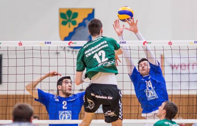 Berlin, Deutschland, 09.02.2016: Volleyball Bundesliga Saison 2015 2016 - Netzhoppers KW-Bestensee - VfB Friedrichshafen. Daniel Heinecke (Netzhoppers 12) gegen den Block aus Maximiliano Gauna (VfB Friedrichshafen 2), Baptiste Geiler (VfB Friedrichshafen 14)