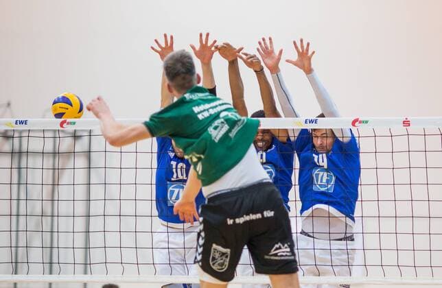 Berlin, Deutschland, 09.02.2016: Volleyball Bundesliga Saison 2015 2016 - Netzhoppers KW-Bestensee - VfB Friedrichshafen. Matthias Böhme Boehme (Netzhoppers 8) gegen den Block aus v.li. Simon Tischer (VfB Friedrichshafen 10), Marc-Anthony Honore (VfB Friedrichshafen 9), Baptiste Geiler (VfB Friedrichshafen 14)