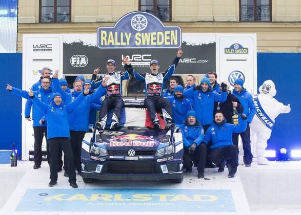 Motorsport, WRC, Rallye Schweden, Siegerehrung 160214 Sebastien Ogier med kartläsare Julien Ingrassia och hela teamet , (Volkswagen Motorsport, Volkswagen Polo WRC Motorsport Rallye WM jublar efter segern vid prisutdelningen under Rally Sweden den 14 februari 2016 i Karlstad.  Copyright: ANNA-LENAxBERGQVIST BB160214BB903