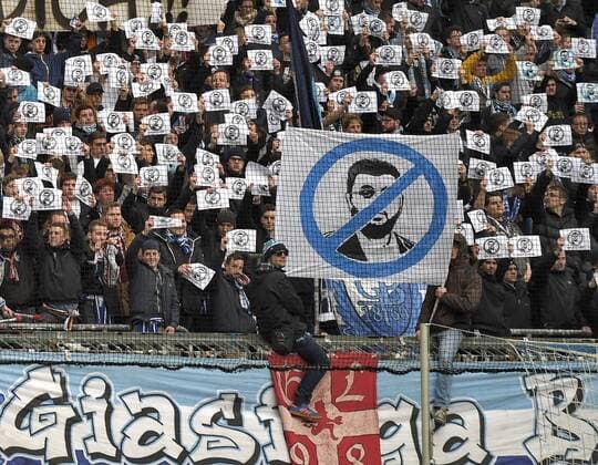 21.02.2016, Fussball 2.Bundesliga 2015 2016, 22.Spieltag, TSV 1860 München - VfL Bochum, in der Allianz-Arena München. Hasan verpiss Dich die Löwenfans in der Nordkurve richten mit diesem Transparent einen Gruss an den Löwen-Investor Hasan Ismaik. Auf ihren Zetteln das durchgestrichene Gesicht von Ismaik mit: NOT WELCOME! (Nicht Willkommen) 