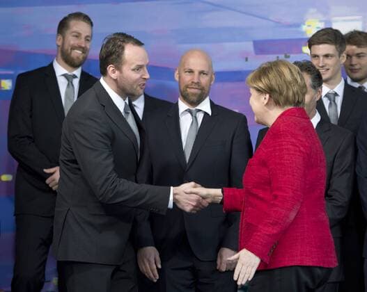 Bundeskanzlerin Dr.Angela MERKEL begruesst Bundestrainer Dagur SIGURDSSON hinten: Teammanager Oliver ROGGISCH, Assistenztrainer Axel KROMER, Rune DAHMKE, Paul DRUX (vl) Empfang der Deutschen Handballnationalmannschaft im Bundeskanzleramt in Berlin, Deutschland am 09.03.2016.