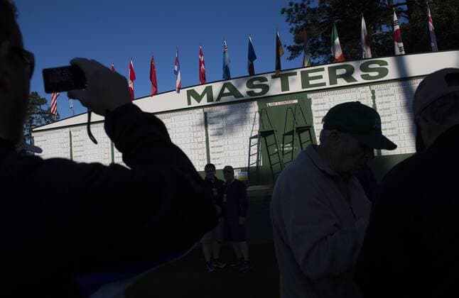 Patrons gather near the Masters scoreboard during a practice round before the 2016 Masters Tournament at Augusta National in Augusta, Georgia on April 5, 2016.  AUG20160405303 KEVINxDIETSCH