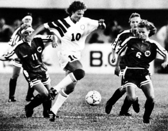 Michelle Akers (10) of the United States, center, breaks through Agnete Carlsen (6), right, and Birthe Hegstad (11), left, of Norway during the final of the First FIFA Womens World Cup in Guangzhou city, south Chinas Guangdong province, 30 November 1991. The United States defeated Norway 2-1 and won the First FIFA Womens World Cup. 1991 FIFA Womens World Cup  p024773_14