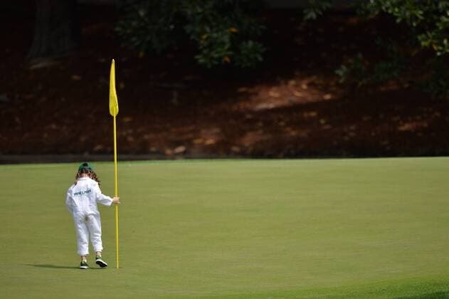 Trevor Immelman s daughter Myra tends the flag on the eighth hole during the Par Three Contest at the 2016 Masters Tournament at Augusta National in Augusta, Georgia on April 6, 2016.  AUG20160406336 KEVINxDIETSCH