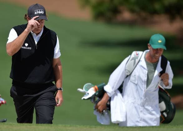 Phil Mickelson tips his cap as he walks with caddie Jim Mackay to the 7th green in the first round of the 2016 Masters Tournament at Augusta National in Augusta, Georgia on April 7, 2016.  MAS20160407157 KEVINxDIETSCH