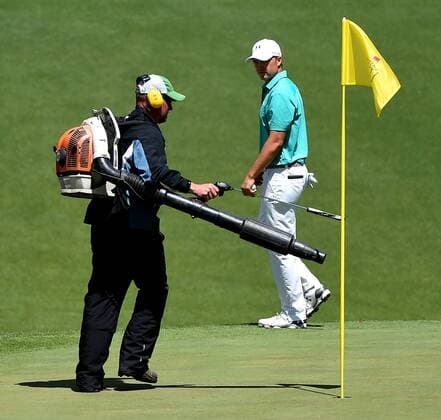 April 7, 2016 - Augusta, GA, USA - A groundskeeper hurries to blow leaves from the 10th green as Jordan Spieth, right, monitors during the first round of the Masters Golf Tournament on Thursday, April 7, 2016, at Augusta National Golf Club in Augusta, Ga. Master s - ZUMAm67_