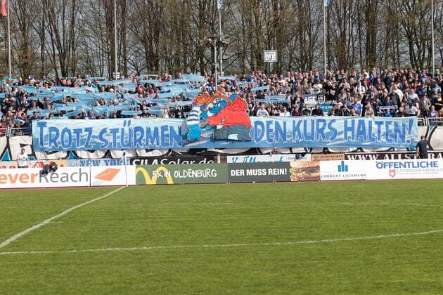 Fußball, Stadiongeschichte VfB Oldenburg Fußball Regionalliga Nord Saison 2015 2016 28. Spieltag am Sonntag, 10. April 2016 im Marschweg-Stadion in Oldenburg: VfB Oldenburg - VfL Wolfsburg II Choreographie der Fans des VfB Oldenburg mit dem Spruchband Trotz Stuermen den Kurs halten VfB Oldenburg - VfL Wolfsburg II