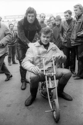 Dieter Braun (BR Deutschland) auf einem Minimotorrad, dahinter Giacomo Agostini (Italien)