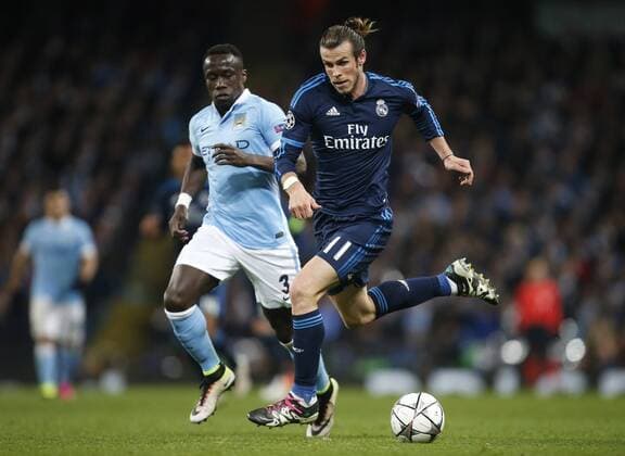 Gareth Bale of Real Madrid escapes Bacary Sagna of Manchester City during the UEFA Champions League Semi Final 1st leg match at the Etihad Stadium. Photo credit should read: Philip Oldham Sportimage EDITORIAL USE ONLY. No use with unauthorised audio, video, data, fixture lists, club league logos or live services. Online in-match use limited to 120 images, no video emulation. No use in betting, games or single club league player publications.