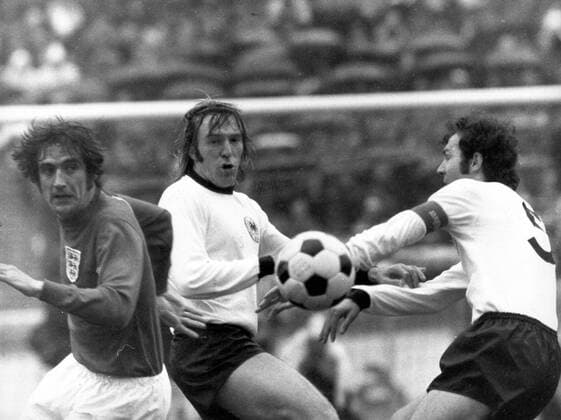 Norman Hunter (England) gegen Günter Netzer und Franz Beckenbauer (beide BR Deutschland)