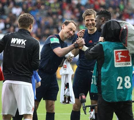 Schiedsrichter Florian Meyer pfeift heute sein letztes Bundesligaspiel, bekommt von Daniel Baier (FC Augsburg 10, li.) ein Trikot und eine Kater-Mikesch-Marionette, Händedruck mit Johan Djourou, SR-Assistent Frank Willenborg, FC Augsburg vs. Hamburger SV, 34. Spieltag, 14.05.2016