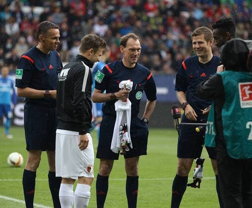 Schiedsrichter Florian Meyer pfeift heute sein letztes Bundesligaspiel, bekommt von Daniel Baier (FC Augsburg 10, li.) ein Trikot und eine Kater-Mikesch-Marionette, mit Johan Djourou, SR-Assistent Frank Willenborg, FC Augsburg vs. Hamburger SV, 34. Spieltag, 14.05.2016