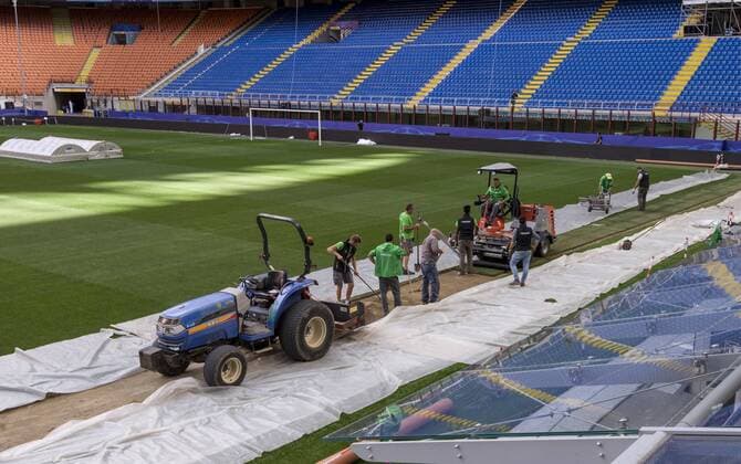 Italy: Giuseppe Meazza stadium - Champion League Workers work on the grass of the pitch. Giuseppe Meazza stadium (also known as San Siro) will host the Champions League final between Real Madrid Cub de Futbol and Club Atletico De Madrid.  NicolòxCampo