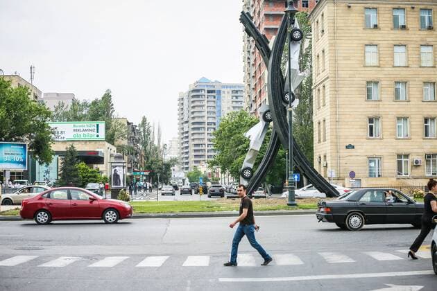 Baku: A silver car advertises A man moving near the silver F1 car.  AzizxKarimov