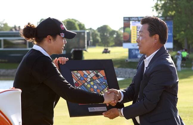 May 29, 2016 - Ann Arbor, Michigan, United States - Kyung Ahn Moon, Chairman of Volvik INC presents Ariya Jutanugarn of Bangkok with the trophy after she won the final round of the inaugural LPGA Golf Damen Volvik Championship at Travis Pointe Country Club in Ann Arbor, MI, USA Sunday, May 29, 2016. LPGA Volvik Championship - Final Round  - ZUMAn230