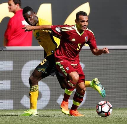Venezuela midfielder Arquimedes Figuera (L) moves the ball as Jamaica midfielder JeVaughn Watson (15) tries to steal during the first half of a 2016 Copa America Centenario Group C match at Soldier Field in Chicago on June 5, 2016.  CHI2016060512 BRIANxKERSEY