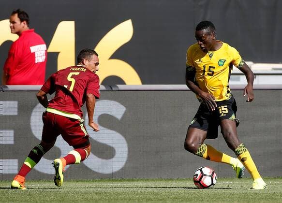 Jamaica midfielder JeVaughn Watson (L) moves the ball as Venezuela midfielder Arquimedes Figuera defends during the first half of a 2016 Copa America Centenario Group C match at Soldier Field in Chicago on June 5, 2016.  CHI2016060513 BRIANxKERSEY