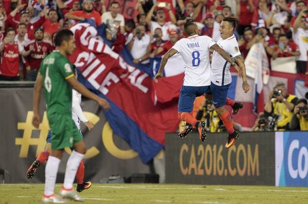 Chile midfielder Arturo Vidal (8) gets a chest bump from forward Eduardo Vargas (11) as Bolivia midfielder Walter Veizaga (6) heads towards the net after Vidal scored on a penalty kick in the second half of the Copa America Centenario Group D match at Gillette Stadium in Foxboro, Massachusetts on on June 10, 2016. Chile defeated Bolivia 2-1.  BOS2016061013 MATTHEWxHEALEY