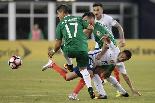 Chile forward Fabian Orellana (19) tangles with Bolivia forward Alejandro Melean (13) as Bolivia Mdefender Marvin Bejarno (17) chases after the ball in the second half of the Copa America Centenario Group D match at Gillette Stadium in Foxboro, Massachusetts on on June 10, 2016. Chile defeated Bolivia 2-1.  BOS2016061015 MATTHEWxHEALEY