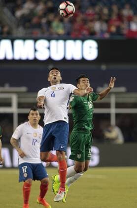 Chile defender Mauricio Isla (4) and Bolivia forward Rodrigo Ramallo (18) go for a header in the second half of the Copa America Centenario Group D match at Gillette Stadium in Foxboro, Massachusetts on on June 10, 2016. Chile defeated Bolivia 2-1.  BOS2016061017 MATTHEWxHEALEY