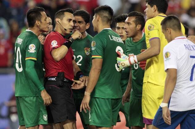 Members of the Bolivia team argue with referee Jair Marrufo after a penalty kick was given to Chile following a handball by Bolivia in the second half of the Copa America Centenario Group D match at Gillette Stadium in Foxboro, Massachusetts on on June 10, 2016. Chile defeated Bolivia 2-1.  BOS2016061019 MATTHEWxHEALEY