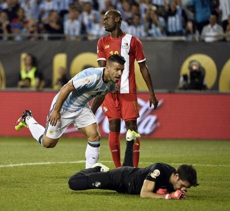 Argentina forward Sergio Aguero (L) reacts after scoring on a header past Panama goalkeeper Jaime Penedo (R) and defender Adolfo Machado during the second half of a 2016 Copa America Centenario Group D match at Soldier Field in Chicago on June 10, 2016. Argentina defeated Panama 5-0.  CHI2016061025 BRIANxKERSEY