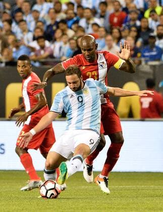 Argentina forward Gonzalo Higuain (L) kicks the ball as Panama defender Felipe Baloy defends during the first half of a 2016 Copa America Centenario Group D match at Soldier Field in Chicago on June 10, 2016. Argentina defeated Panama 5-0.  CHI2016061008 BRIANxKERSEY