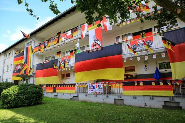 Deutschland-Fahnen hängen an anläßlich der Fußball-EM 2016 in Frankreich an einer Hausfassade in Köln. Fahnen zur Fußball-EM