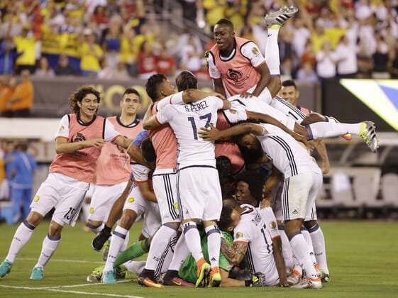 The Colombia team pile on goalie David Ospina after their victory over Peru at the Copa America Centenario USA 2016 quarter-finals at MetLife Stadium in East Rutherford, New Jersey on June 17, 2016. Colombia defeated Peru 0-0 and 4-2 on penalties.  NYP20160617137 JOHNxANGELILLO
