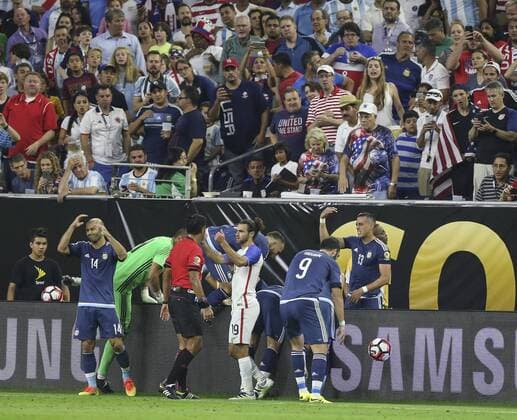 Players help Argentina s Ezequiel Lavezzi, who fall down over the billboard, during a Copa America 2016 semifinal match between Argentina and the United States at NRG Stadium in Houston, Texas, United States, 21 June 2016. United States vs. Argentina !ACHTUNG: NUR REDAKTIONELLE NUTZUNG!  HOU078 20160622-636021675528820152