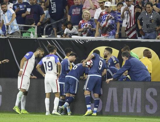 Players help Argentina s Ezequiel Lavezzi, who fall down over the billboard, during a Copa America 2016 semifinal match between Argentina and the United States at NRG Stadium in Houston, Texas, United States, 21 June 2016. United States vs. Argentina !ACHTUNG: NUR REDAKTIONELLE NUTZUNG!  HOU078 20160622-636021675540520152