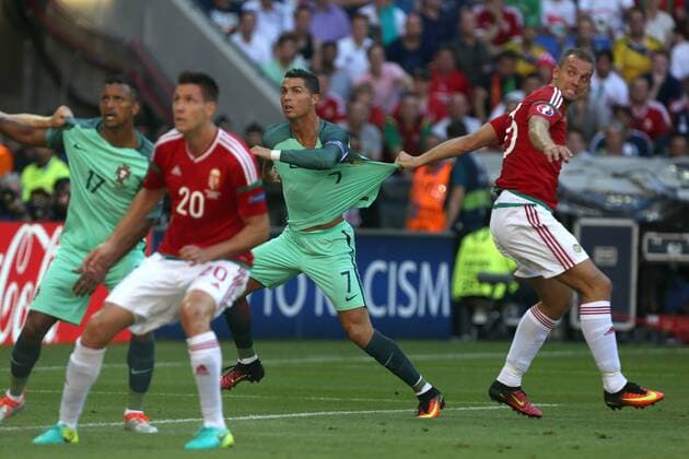 Roland Juhasz of Hungary tugs at the shirt of Cristiano Ronaldo of Portugal during the UEFA European Championship EM Europameisterschaft 2016 match at the Stade de Lyon, Lyon. Picture date June 22nd, 2016 Pic Phil Oldham Sportimage EDITORIAL USE ONLY. No use with unauthorised audio, video, data, fixture lists, club league logos or live services. Online in-match use limited to 120 images, no video emulation. No use in betting, games or single club league player publications.