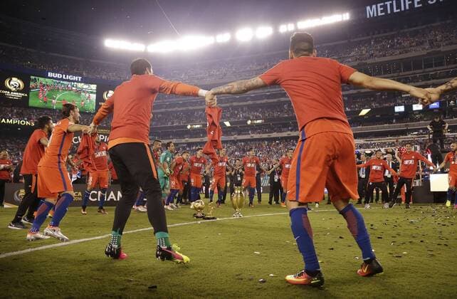 Team Chile celebrate around the championship trophy after defeating Argentina at the Copa America Centenario USA 2016 Finals at MetLife Stadium in East Rutherford, New Jersey on June 26, 2016. Chile defeated Argentina 4-2 in penalty kicks and won there second consecutive Copa America.  NYP20160626108 JOHNxANGELILLO