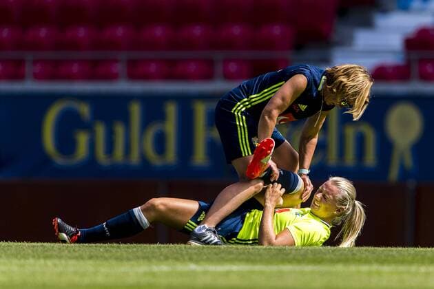 160720 Stina Blackstenius far hjälp med stretching av Sveriges sjukgymnast Annica Näsmark under en träning med det svenska damlandslaget i fotboll den 20 juli 2016 i Kalmar.  Copyright: JonasxLjungdahl BB160720JO004